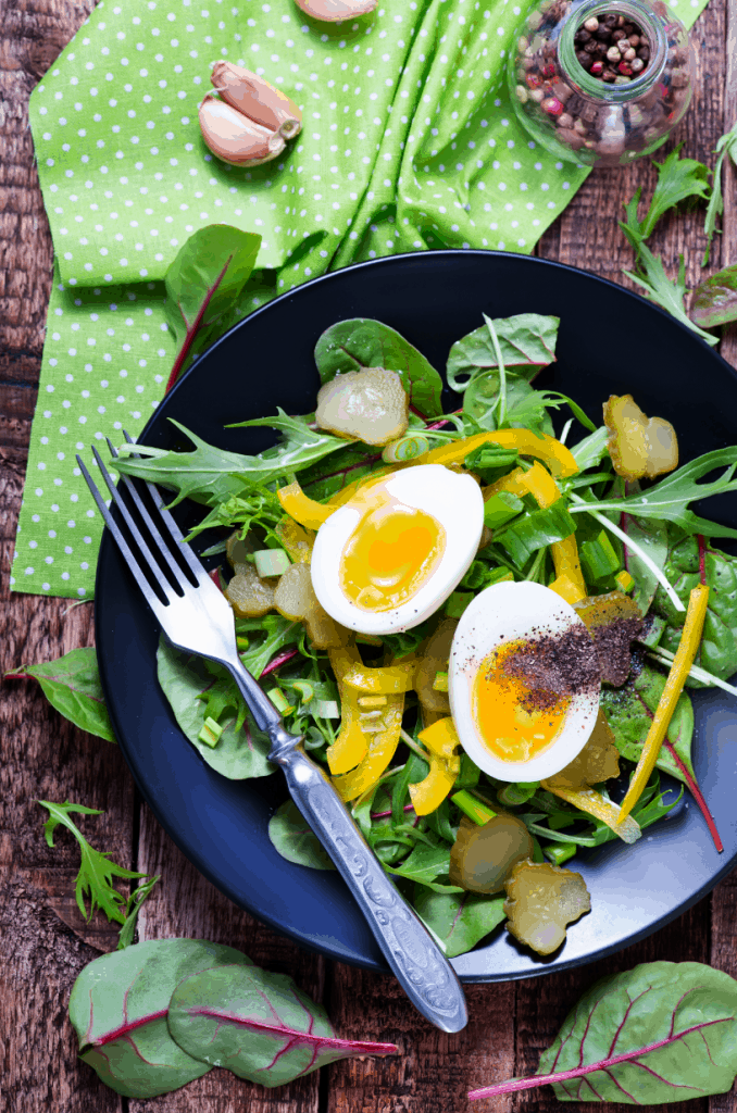 A green salad with soft boiled eggs